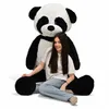 A young woman is sitting in front of a very large stuffed panda toy. Produktbild-Vorschau