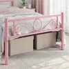 A close-up view of a pink metal bed frame with storage boxes underneath. Produktbild-Vorschau