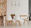 A dining room with a wooden table and chairs, illuminated by pendant lights. Produktbild-Vorschau
