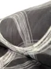 A close-up view of a folded grey blanket with a white abstract pattern of circles and stripes. Produktbild-Vorschau
