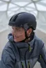 A person wearing a helmet and jacket in the rain. Produktbild-Vorschau