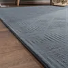 A close-up view of a gray rug with a geometric pattern, placed on a wooden floor. Anteprima dell’immagine prodotto