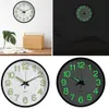 A collage of four images showing a glowing wall clock in different lighting conditions and angles. Voir les images du produit
