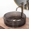 A close-up shot of a black glass vessel sink with a gold faucet. Anteprima dell’immagine prodotto