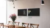 A dining room setting with two black magnetic chalkboards mounted on a wall above a wooden dining table with chairs. A vase of pink flowers is on the table. Produktbild-Vorschau