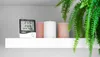 A digital thermometer and hygrometer sits on a white shelf next to three candles and a fern. Anteprima dell’immagine prodotto