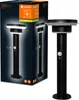 A black outdoor lamp with a motion sensor, shown next to its packaging. Produktbild-Vorschau