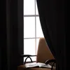 A chair with an open book in front of a window with dark curtains. Náhľad obrázku produktu
