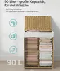 A woven laundry basket filled with folded linens, with descriptive text and icons on the left. Produktbild-Vorschau