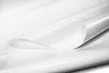 A close-up, studio shot of a white PVC tarpaulin material, with one edge curled to reveal the underside. Produktbild-Vorschau