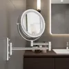 A bathroom vanity area with a wall-mounted magnifying mirror.