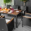 An outdoor dining set with chairs and a table on a wooden deck, set with plates, glasses, and fruit. Náhled obrázku produktu