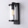 A black and clear glass outdoor wall light with an Edison-style bulb. Produktbild-Vorschau