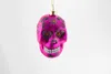A pink glass skull ornament hangs against a white background. Produktbild-Vorschau