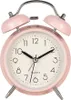 A pink analog alarm clock with silver bells on top, set against a white background. Voir les images du produit