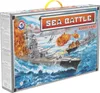 The image shows the front of a board game box depicting a naval battle scene with battleships, explosions, and airplanes. Anteprima dell’immagine prodotto