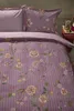 A close-up view of a floral patterned duvet cover and pillowcase set on a bed. Produktbild-Vorschau