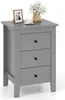 A gray three-drawer nightstand with a framed photo, a cup of coffee, and a vase of flowers on top. Podgląd zdjęcia produktu