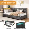 A modern upholstered bed with integrated LED lighting and USB charging, shown in a bedroom setting with decorative wall art. Produktbild-Vorschau