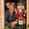 A nutcracker figure stands in the foreground, with a blurred couple in the background. Podgląd zdjęcia produktu