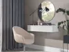 A modern vanity area with a chair, floating desk, mirror, and plant. Produktbild-Vorschau