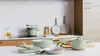 A collection of sage green cookware is displayed on a kitchen counter. Podgląd zdjęcia produktu