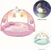 A pink baby play gym with toys and a pillow, shown with a separate inset image of a removable night light and another inset image showing a blue version of the play gym. Náhled obrázku produktu