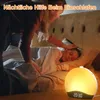 A mother tucks her child into bed, with a sunrise alarm clock glowing on the nightstand. Produktbild-Vorschau