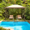 A pop-up gazebo is set up next to a swimming pool in a lush garden. Voir les images du produit