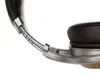 A close-up detail of a pair of headphones, focusing on the headband and ear cup connection. Náhled obrázku produktu