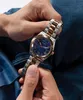 A person is holding a watch. Produktbild-Vorschau