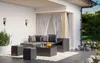 An outdoor patio set with a sectional sofa, coffee table, and ottomans on a wooden deck, surrounded by plants and flowers. Náhled obrázku produktu