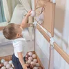 A baby playing with a ball in a playpen. Anteprima dell’immagine prodotto