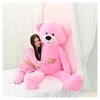 A young woman is hugging a large pink teddy bear on a bed. Anteprima dell’immagine prodotto