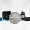 A collection of small electronic devices and a coin cell battery are arranged on a white surface with a light gray circular pattern in the background. Anteprima dell’immagine prodotto