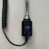 A close-up shot of a black electric heating element with a silver heating rod and a coiled black power cord attached to a light gray wall. Náhľad obrázku produktu