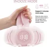 A hand is holding a pink bunny-shaped alarm clock with a digital display showing the time. Produktbild-Vorschau