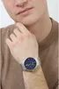 A man wearing a brown sweater and a silver watch with a blue face. Náhľad obrázku produktu