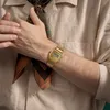 A person wearing a gold Casio watch and a patterned scarf. Voir les images du produit