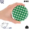 A hand holding a green and white checkered jar lid. Podgląd zdjęcia produktu