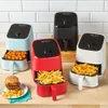 Four Instant Pot air fryers in different colors (light blue, red, black, white) are arranged on a wooden surface in front of a tiled wall. The light blue air fryer contains tater tots, the red one contains French fries, and the white one also contains Fren Podgląd zdjęcia produktu