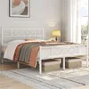 A white metal bed frame with a diamond pattern headboard is set up in a room with bedding and two woven storage baskets underneath. Podgląd zdjęcia produktu