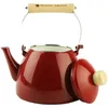 A red enamel kettle with a wooden handle and lid is shown against a white background. The lid is partially open. Podgląd zdjęcia produktu