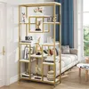 A modern gold and white bookshelf filled with decorative items, placed in a living room setting next to a sofa and a window. Produktbild-Vorschau
