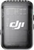 A close-up, front-facing studio shot of a DJI Mic 2 Transmitter in Shadow Black, showcasing its transparent casing and internal components. Náhled obrázku produktu