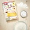 A box of Dr. Oetker Zitronen Wolke cake mix is shown next to bowls of powdered sugar and cake mix, with some powdered sugar scattered in a cloud shape. Produktbild-Vorschau