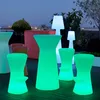 An outdoor patio at dusk with illuminated bar stools and tables. Produktbild-Vorschau