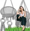A woman sits in a hanging chair, with another chair and some hanging rings visible. Voir les images du produit