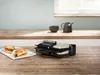 A Bosch grill is shown on a wooden countertop with two sandwiches on a white plate in front of it. Podgląd zdjęcia produktu