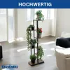 A multi-tiered plant stand filled with various potted plants is placed in a well-lit living room with a sofa visible in the background. Produktbild-Vorschau